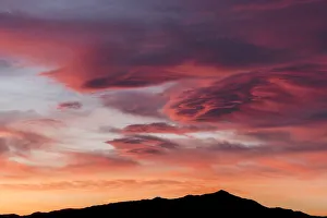 Sunset lights up clouds above mountain ridge in Joshua Tree National Parks southern region, California, USA Sunset lights up clouds above mountain ridge in Joshua Tree National Parks southern region, California, USA