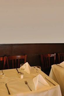 Table at restaurant, tablecloth, cutlery, wine glasses, napkins, wooden panelling Table at restaurant, tablecloth, cutlery, wine glasses, napkins, wooden panelling