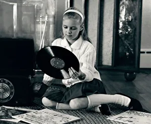 Teen girl with vinyl records and record player, sitting on floor Teen girl with vinyl records and record player, sitting on floor