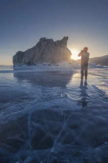 Tourist talking photo at frozen Lake Baikal Tourist talking photo at frozen Lake Baikal