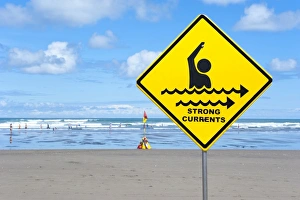 Warning sign strong currents, on a beach, Muriwai Beach, West Coast, Auckland Warning sign strong currents, on a beach, Muriwai Beach, West Coast, Auckland