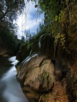 Waterfall illuminated by moonlight in a ravine Waterfall illuminated by moonlight in a ravine