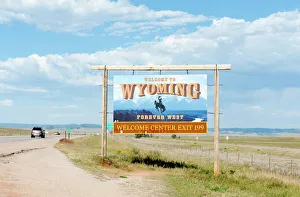 Welcome sign on a highway, Welcome to Wyoming, Forever West, flat landscape, Wyoming, USA Welcome sign on a highway, Welcome to Wyoming, Forever West, flat landscape, Wyoming, USA