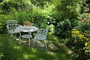 White metal garden table and chairs in a residential backyard, Quebec City White metal garden table and chairs in a residential backyard, Quebec City