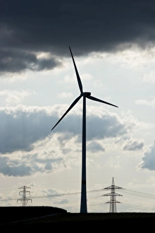 Wind turbine, utility poles and power lines, silhouettes, Oening, Bavaria, Germany Wind turbine, utility poles and power lines, silhouettes, Oening, Bavaria, Germany