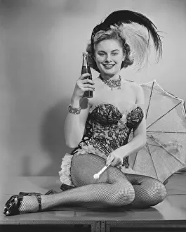 Woman in corsets and fancy hat posing in studio (B&W), portrait Woman in corsets and fancy hat posing in studio (B&W), portrait