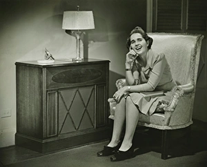 Woman sitting in armchair, smiling, (B&W) Woman sitting in armchair, smiling, (B&W)