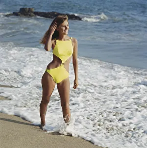 Woman in yellow swimwear standing on beach, smiling Woman in yellow swimwear standing on beach, smiling