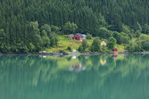Wooden farmhouses on hill by fjord, Olden, Norway Wooden farmhouses on hill by fjord, Olden, Norway