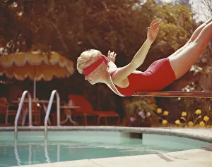 Young woman with blindfold balancing on diving board Young woman with blindfold balancing on diving board