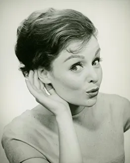 Young woman cupping hand to ear, (B&W), (Portrait) Young woman cupping hand to ear, (B&W), (Portrait)