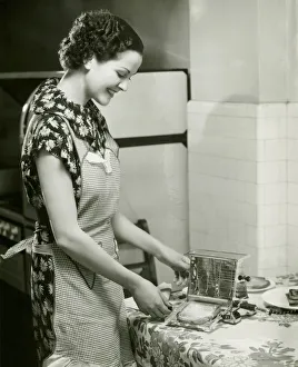 Young woman making slice of toast, (B&W), portrait Young woman making slice of toast, (B&W), portrait