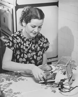 Young woman preparing toasts at kitchen table (B&W) Young woman preparing toasts at kitchen table (B&W)