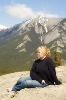Young woman sitting in the mountains, Jasper, Canada Young woman sitting in the mountains, Jasper, Canada