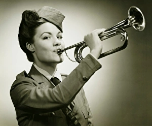 Young woman in soldiers uniform playing on trumpet, (B&W), portrait Young woman in soldiers uniform playing on trumpet, (B&W), portrait