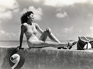 Young woman wearing knitted swimsuit, posing on wall by ocean. (Photo by H. Armstrong Roberts/Retrofile/Getty Images) Young woman wearing knitted swimsuit, posing on wall by ocean. (Photo by H. Armstrong Roberts/Retrofile/Getty Images)