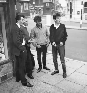1962 Men standing on a street corner in East Grinstead, West Sussex watching girls go by 1962 Men standing on a street corner in East Grinstead, West Sussex watching girls go by