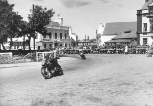 Competitors passing Ramsay Town Square at speed. Number 69 is W. J Competitors passing Ramsay Town Square at speed. Number 69 is W. J