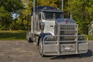 Kenworth 6x4 semi unit parked in the sun against gorgous autumn colours Kenworth 6x4 semi unit parked in the sun against gorgous autumn colours