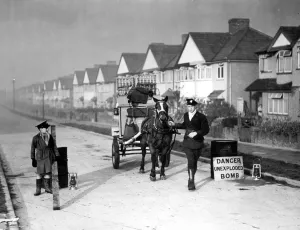 Milk man with his horse and float stands in a street where an unexploded bomb has Milk man with his horse and float stands in a street where an unexploded bomb has