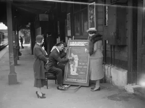 People gather round to watch the railway porter sign writer Mr E A Burgar. 1938 People gather round to watch the railway porter sign writer Mr E A Burgar. 1938