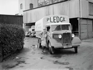 A worker chats to the driver of a loaded Bedford truck belonging to Pledge & Son Ltd A worker chats to the driver of a loaded Bedford truck belonging to Pledge & Son Ltd