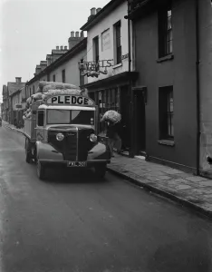 Workers are unloading sacks of flour from a Bedford truck belonging to Pledge & Son Ltd Workers are unloading sacks of flour from a Bedford truck belonging to Pledge & Son Ltd