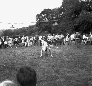 A crowd of people gathered to watch a Cornish wrestling match at an unknown location A crowd of people gathered to watch a Cornish wrestling match at an unknown location