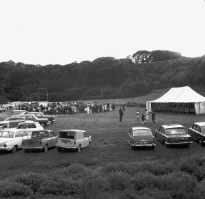 A crowd of people gathering to watch a Cornish wrestling match at an unknown location A crowd of people gathering to watch a Cornish wrestling match at an unknown location