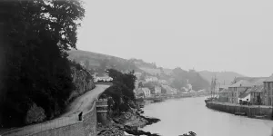 Prints of A view up river from Hannafore Road. A man is leaning on the railings near to the castellated turret on the left hand side. Photographer: Unknown Looe Prints: Print of The River Looe, Cornwall, early 1900s