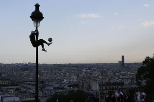 Iya Traore, a former professional football player, holds on to a lamppost as he performs Iya Traore, a former professional football player, holds on to a lamppost as he performs