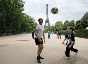 People play football on May 29, 2014 in front of the Eiffel tower, in Paris People play football on May 29, 2014 in front of the Eiffel tower, in Paris