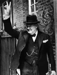 Prints of British Premier Sir Winston Churchill flashes to the crowd outside 10 Downing Street his famous V-sign signifying Victory when he returned to London in 1943 from one of his trips to Washington London Prints: Black and White Print of Winston Churchill Making the V Sign
