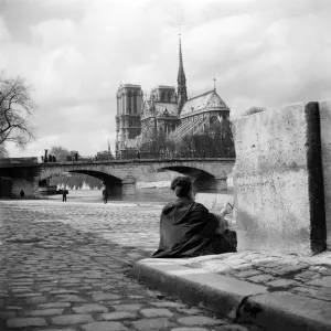 woman paints Notre-Dame Cathedral on the banks of the Seine woman paints Notre-Dame Cathedral on the banks of the Seine