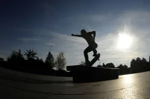 A youth performs a trick on his skateboard during a warm autumn sunny day on October 4 A youth performs a trick on his skateboard during a warm autumn sunny day on October 4