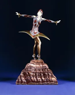 Kora, a figure of an exotic dancer, (gilt, cold-painted bronze and ivory on red marble plinth) Kora, a figure of an exotic dancer, (gilt, cold-painted bronze and ivory on red marble plinth)