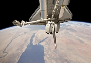 The aft section of the docked space shuttle Discovery and the stations robotic Canadarm2 The aft section of the docked space shuttle Discovery and the stations robotic Canadarm2