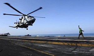 Airman directs an EH-101 Merlin helicopter onto the flight deck of USS John C. Stennis Airman directs an EH-101 Merlin helicopter onto the flight deck of USS John C. Stennis