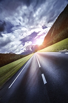 An asphalt road leading to the Dolomite Alps at sunset, Northern Italy An asphalt road leading to the Dolomite Alps at sunset, Northern Italy