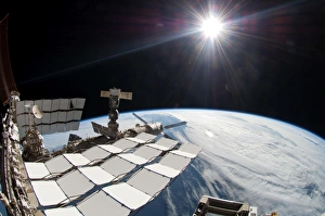 The bright sun, a portion of the International Space Station and Earths horizon The bright sun, a portion of the International Space Station and Earths horizon