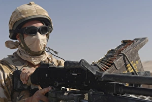 A British Army soldier mans a machine gun mounted on top of a land rover A British Army soldier mans a machine gun mounted on top of a land rover