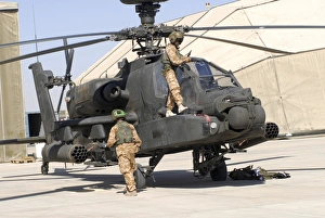 British soldiers perform maintenance on an Apache helicopter British soldiers perform maintenance on an Apache helicopter