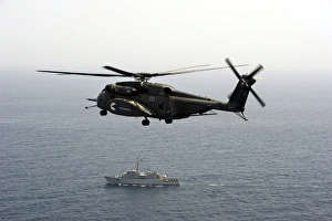 A CH-53 Sea Stallion flies above the mine countermeasures ship USS Ardent A CH-53 Sea Stallion flies above the mine countermeasures ship USS Ardent