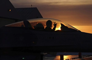 An F-16 Fighting Falcon Fighter Pilot gives the mission accomplished sign while taxiing An F-16 Fighting Falcon Fighter Pilot gives the mission accomplished sign while taxiing