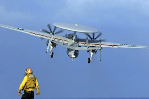 A flight deck director watches an E-2C Hawkeye taking off A flight deck director watches an E-2C Hawkeye taking off