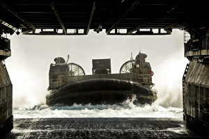 A landing craft air cushion prepares to enter the well deck of the assault ship USS A landing craft air cushion prepares to enter the well deck of the assault ship USS