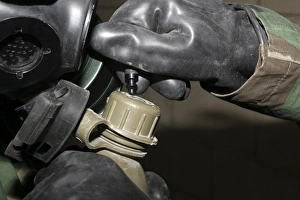 A Marine inserts a drinking tube into his canteen A Marine inserts a drinking tube into his canteen