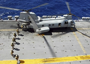 Marines board a CH-46E Sea Knight helicopter on the flight deck of USS Peleliu Marines board a CH-46E Sea Knight helicopter on the flight deck of USS Peleliu