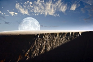 Full moon rising above a sand dune Full moon rising above a sand dune