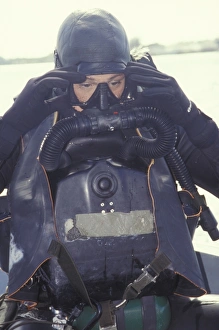 A Navy SEAL combat swimmer adjusts his dive mask A Navy SEAL combat swimmer adjusts his dive mask